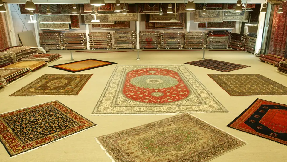 Die Ausstellungshalle des Orient-Teppich-Palais 1001 Nacht mit ausgelegten Orientteppichen und Teppichstapeln