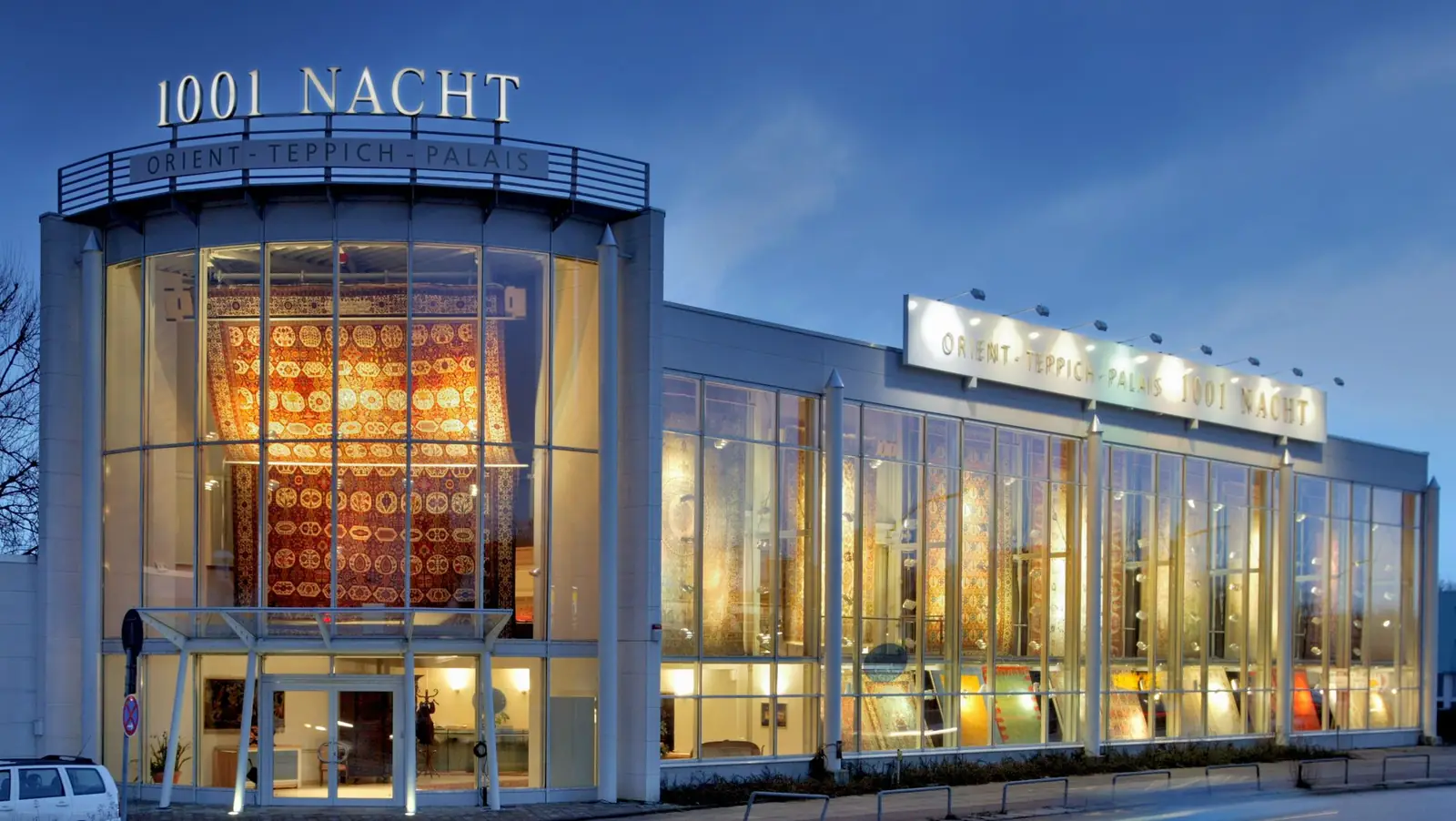 Das Orient-Teppich-Palais 1001 Nacht in der Papenreye 1 in Hamburg am Abend: beleuchtete Glasfassade mit großen Orientteppichen